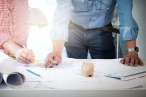 Image of engineer meeting for architectural project. working with partner and engineering tools on workplace vintage tone.